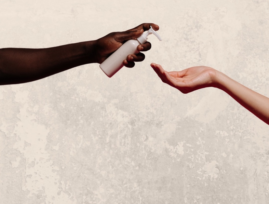 Hands sharing a pump bottle of body lotion