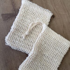 Two white mesh bags on wood table.