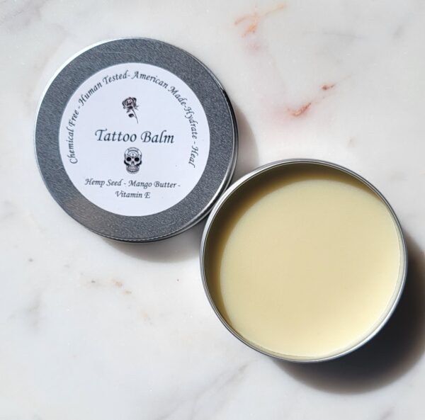 Tattoo balm in tin with yellow cream.