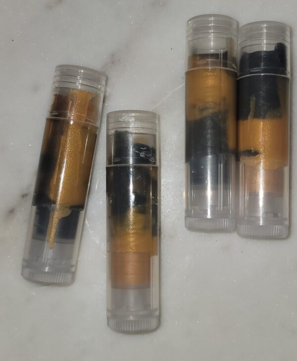 Four gold and black lip balms.