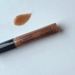 Brown lip gloss tube on white background.