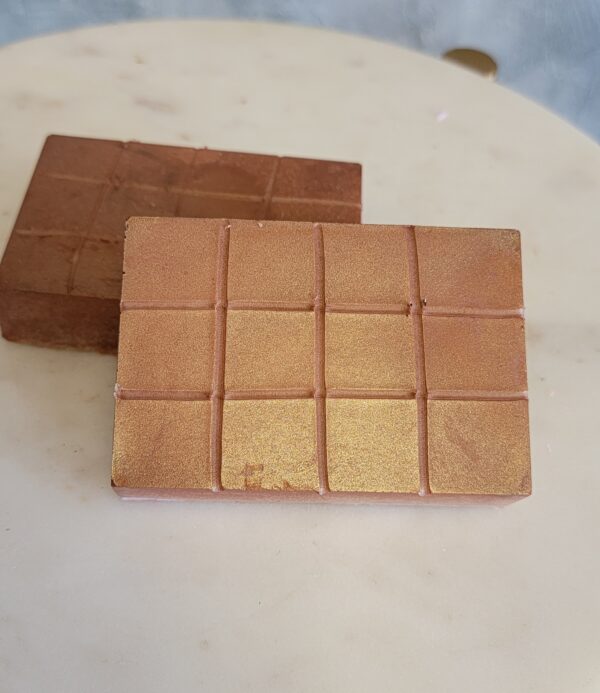 Two bars of gold soap on counter.