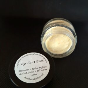 Eye cream in a jar on a black surface.