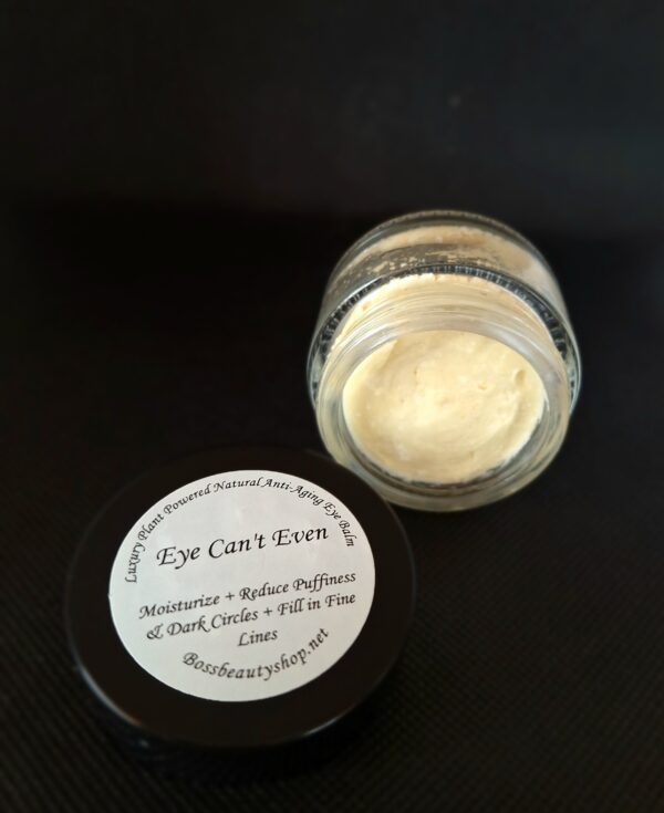 Eye cream in a jar on a black surface.