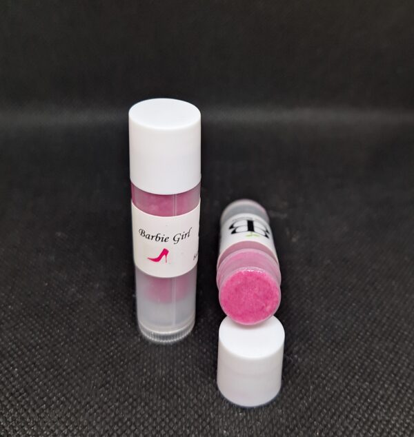 Two pink lip balms on black surface.