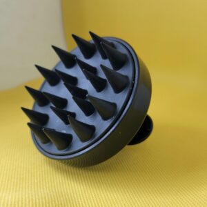 Black scalp massager with spikes.