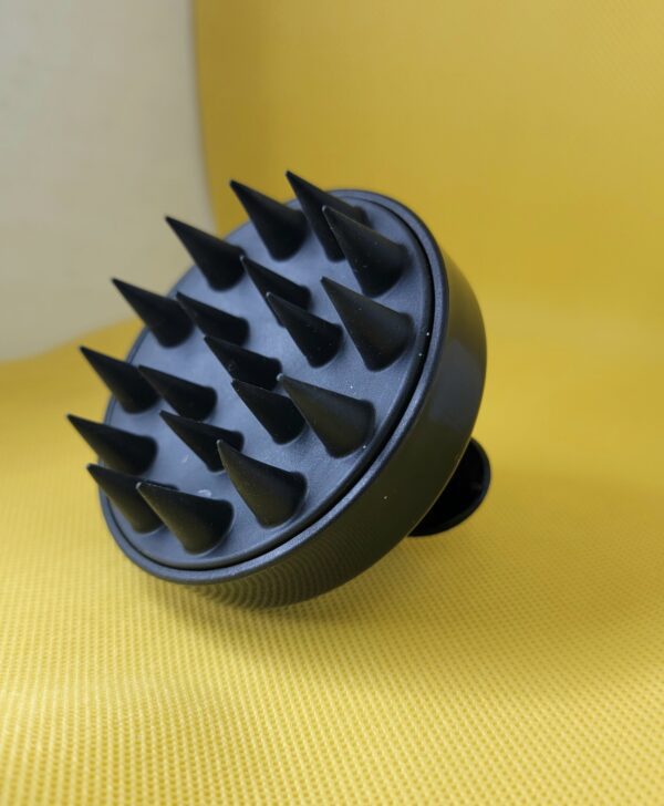 Black scalp massager with spikes.