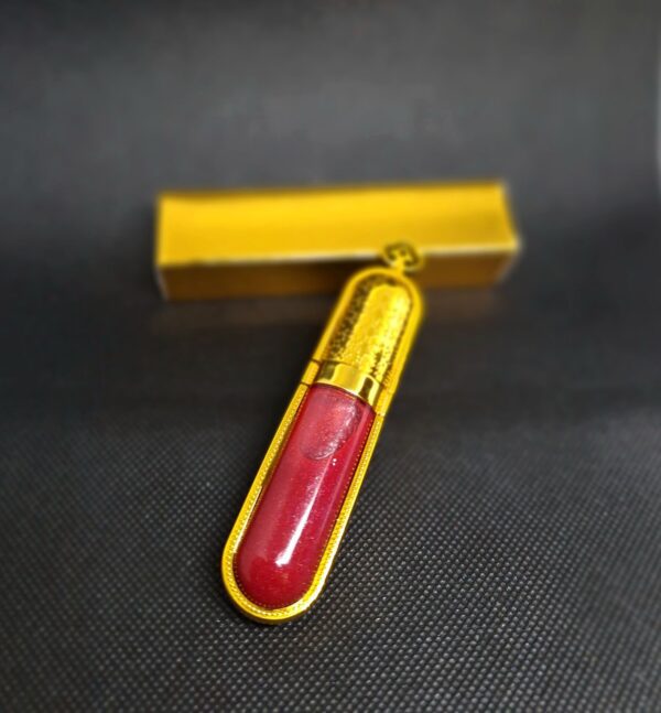 Gold lip gloss tube with red liquid.