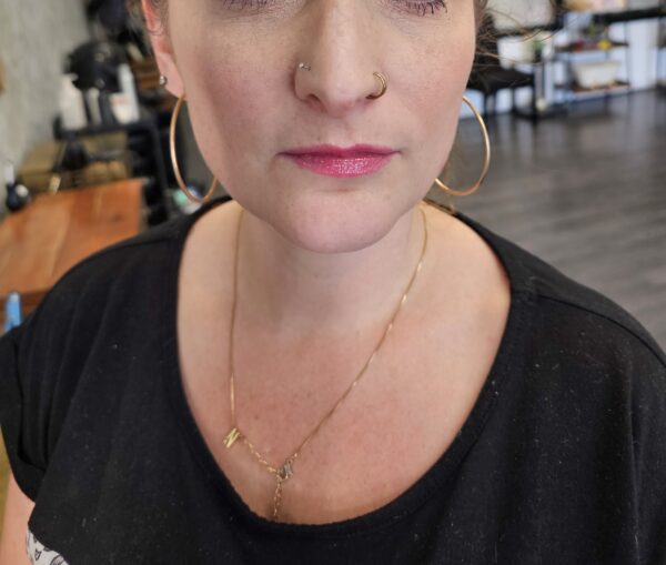 Woman with nose ring and hoop earrings.